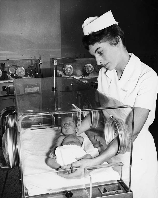 Miss Haxby is holding a newborn baby that is in an incubator at the Toronto Western Hospital in Toronto, Ontario